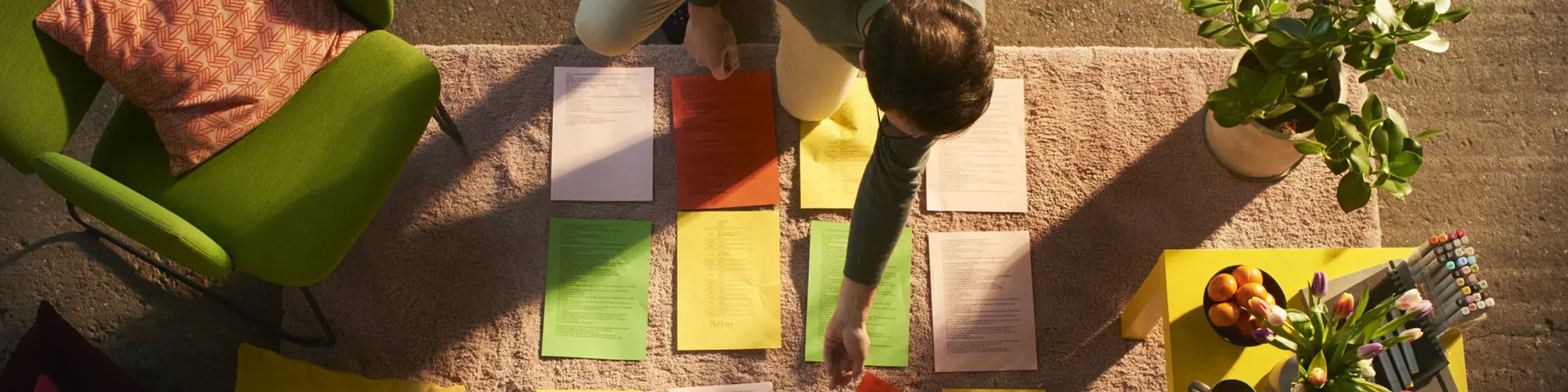 Person lägger färgglada lappar på ett golv