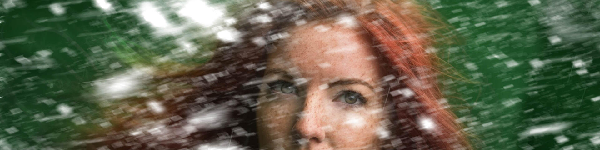 Kvinna med rött hår som står mitt i en storm.