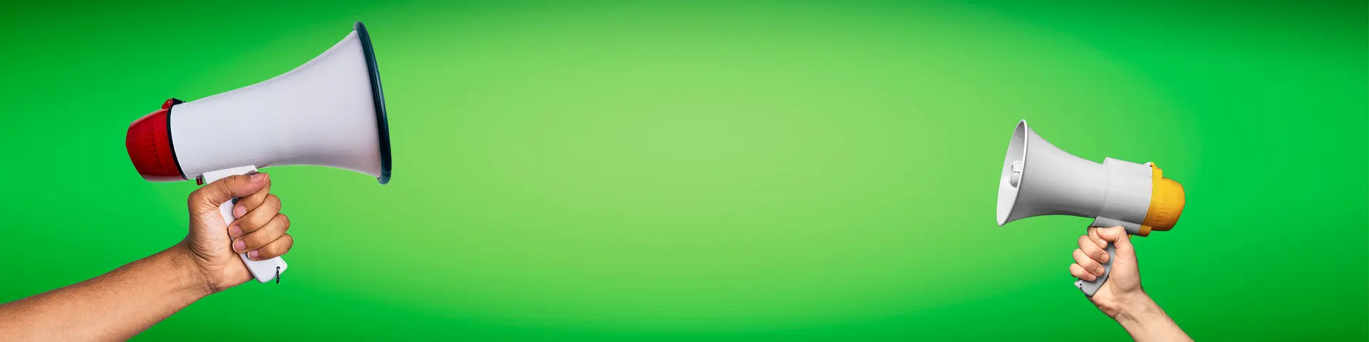 Två händer som håller i megafoner.