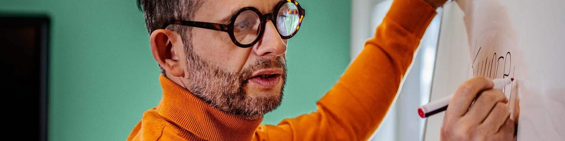 Person skriver på en whiteboard