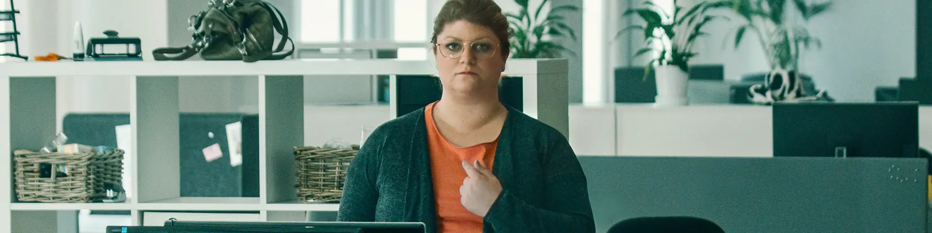 Kvinna som ser orolig ut och pekar på sig själv undrande.