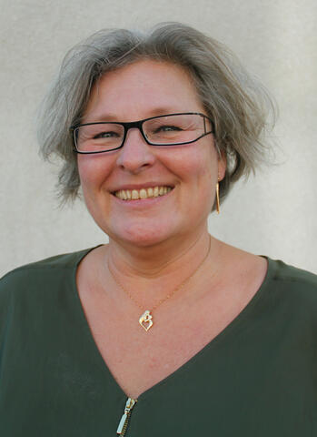 Porträtt av Marie Zeidlitz i grön blus, grått hår och glasögon