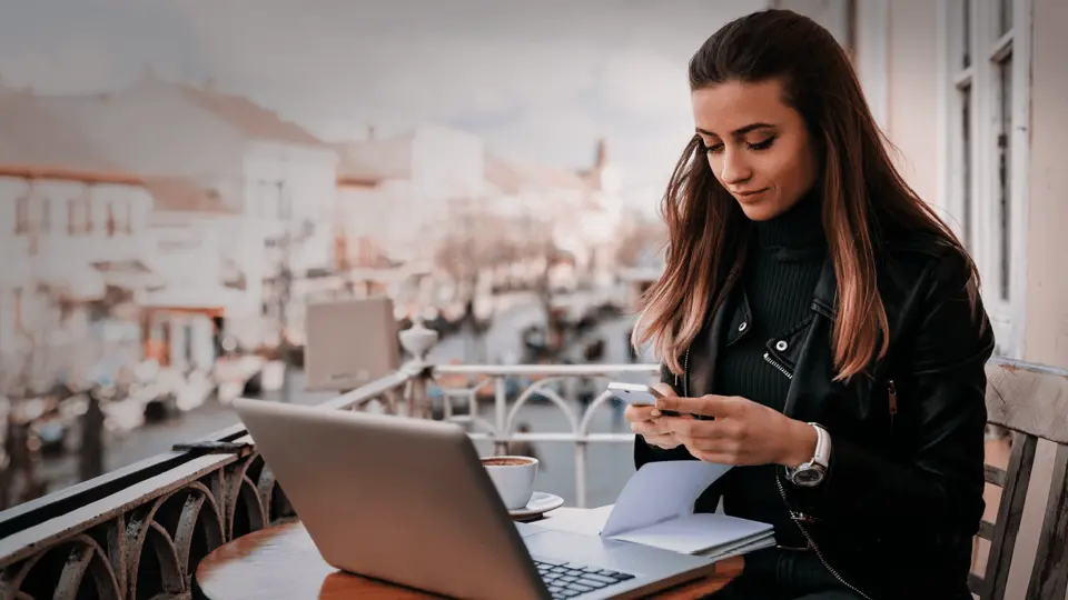 Jobbar vid laptop utomhus på balkong 