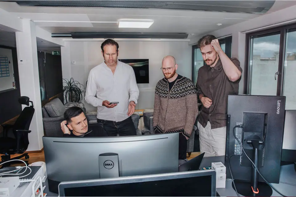 Medelålders män tittar på samma datorskärm
