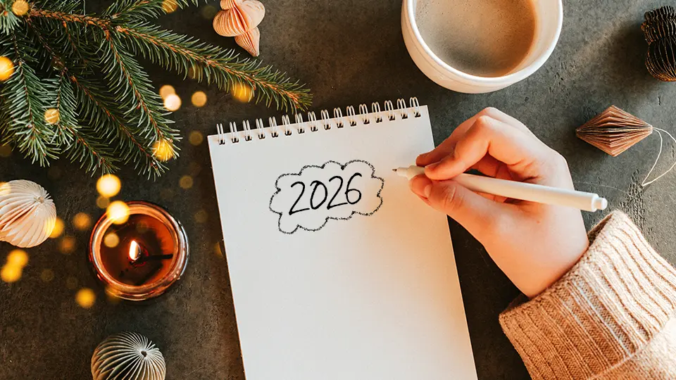 Kvinna sitter vid skrivblock och planerar framtiden.