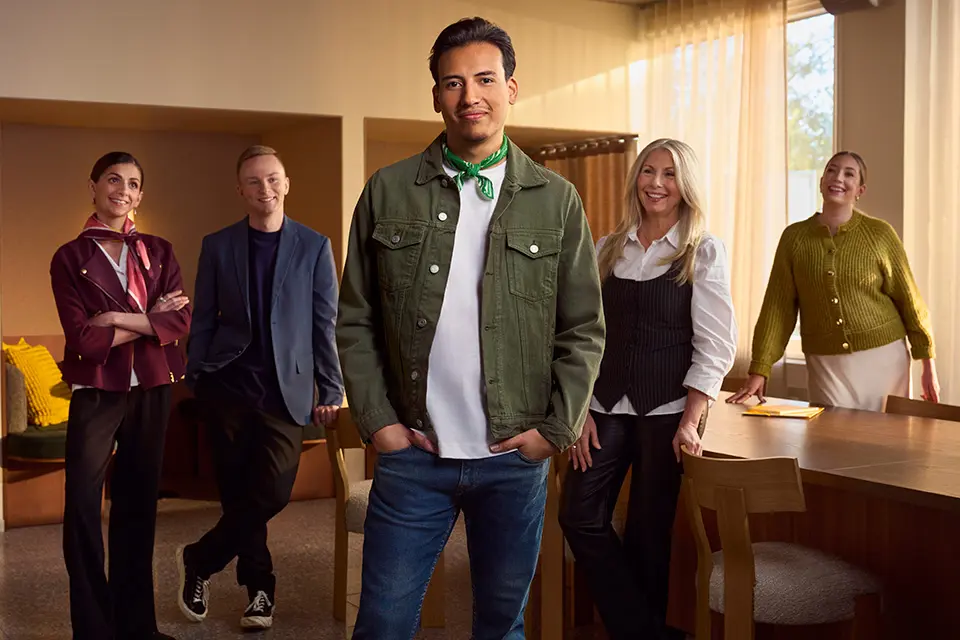 Fem personer står stolta och nöjda på en arbetsplats