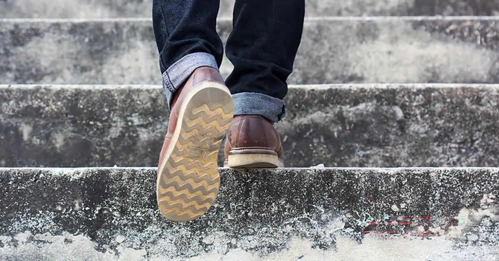 En man som går i trappan - och halkar! Anmäl arbetsskada om det var på väg till jobbet!