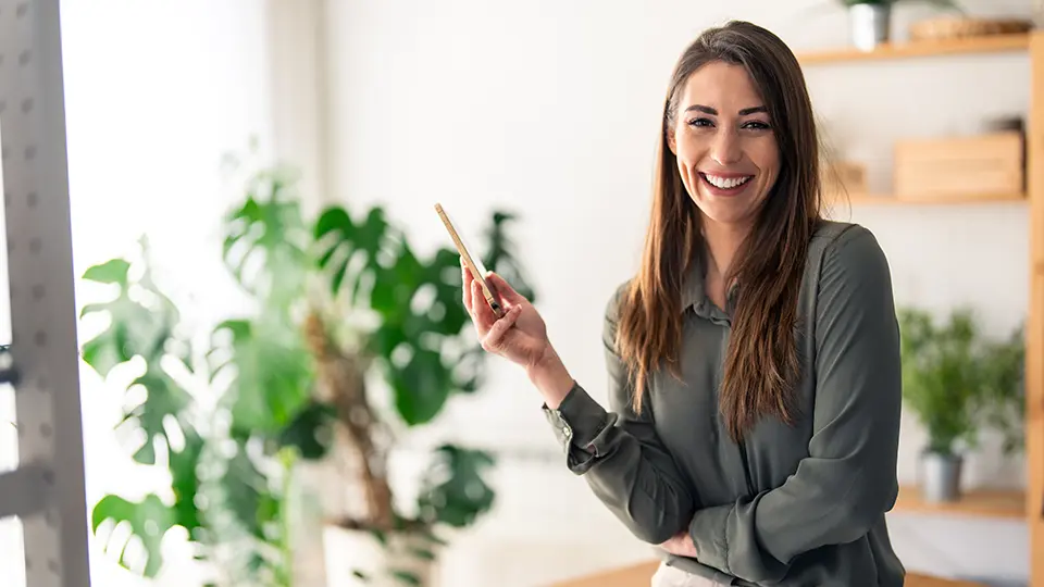 Kvinna i grön skjorta, långt brunt hår, glad 