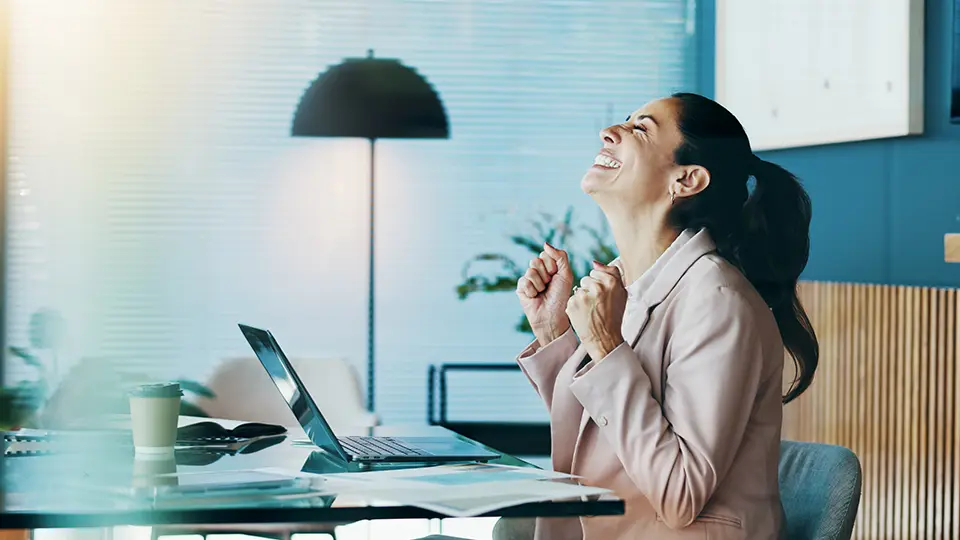 Lycklig kvinna framför dator. 