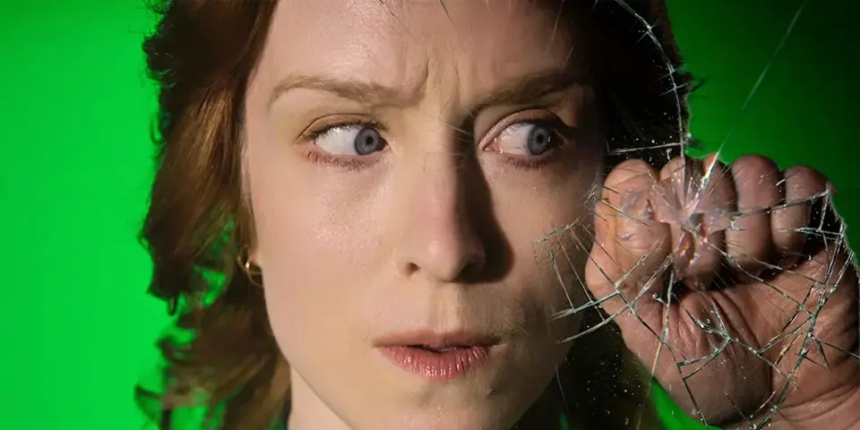 Kvinna som ser orolig ut och knackar på skärmen, som börjar spricka.