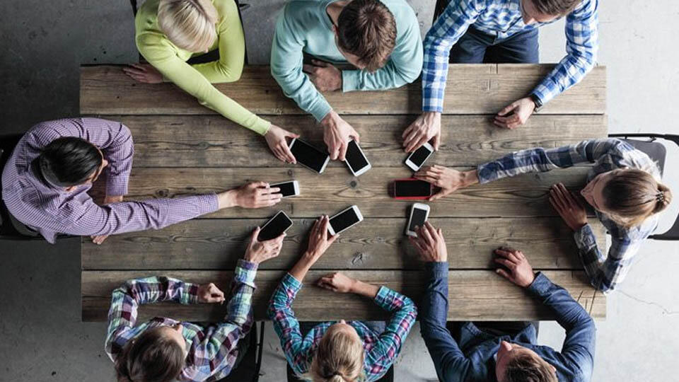 Personer lägger mobiler på bordet