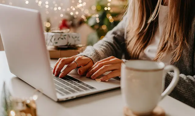 Kvinna sitter vid laptop, och höjer kompetensen med en gratis kurs.