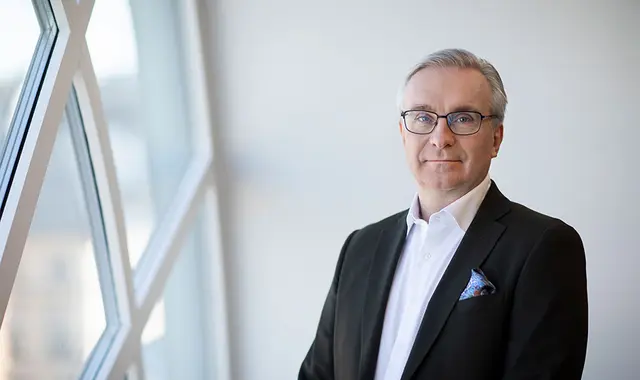 Pressbild på Unionens förbundsordförande Peter Hellberg intill ett fönster.