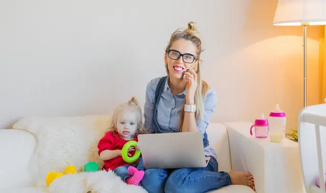 Mamma och barn sitter i en soffa