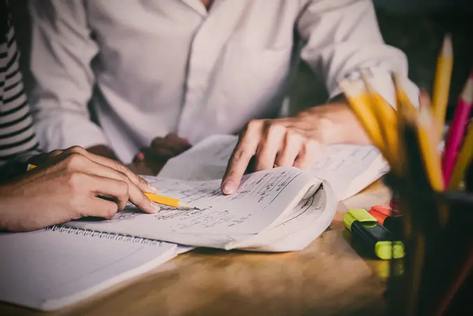 Personer som pekar och markerar i ett papper