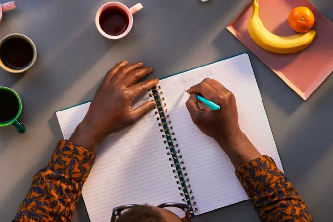 Foto på person som skriver i ett block