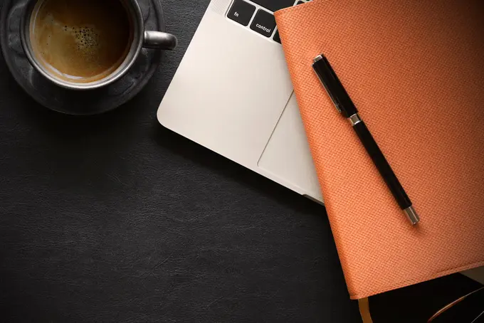 Dator, block och kaffekopp