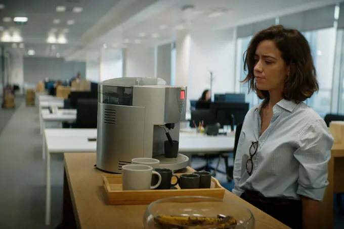 Tjej ser sig oroligt omkring på arbetsplatsen