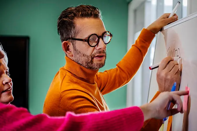 Två personer skriver whiteboardtavla