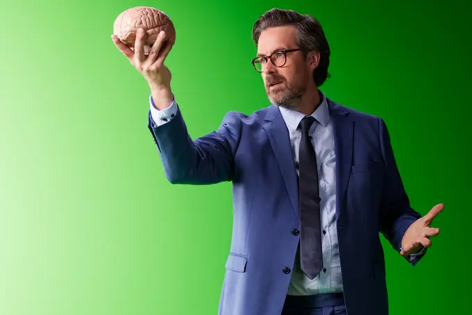 Man som håller ett skeletthuvud i handen och tittar mot det, som i Hamlet.