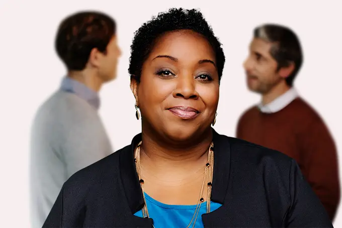 Kvinna i förgrunden, två manliga kollegor längre bak i bilden.