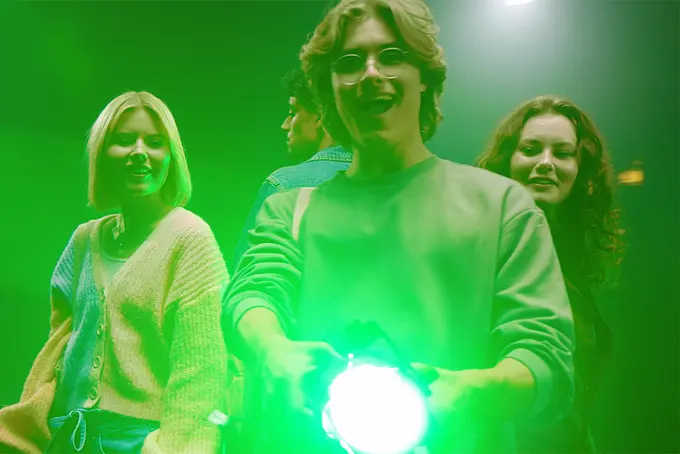 Glada ungdomar lyser med grönt sökljus