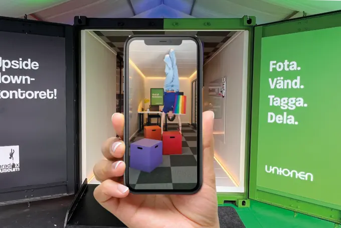 Svart och grön container med mobilkamera framför