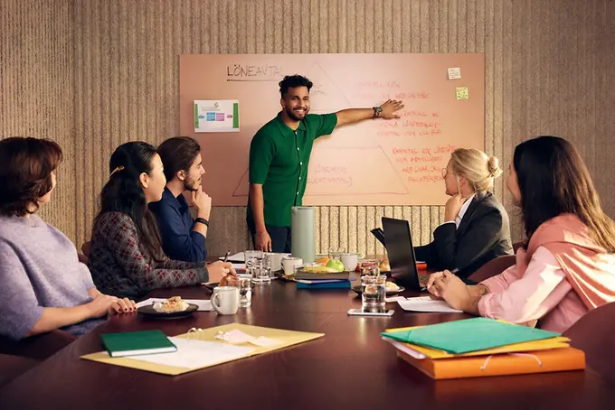 Gruppmöte och ung person vid whiteboard