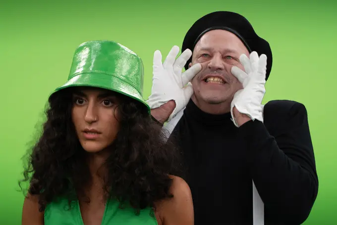 Man som ser ut som en mimare ropar störigt i en tjejs öra.