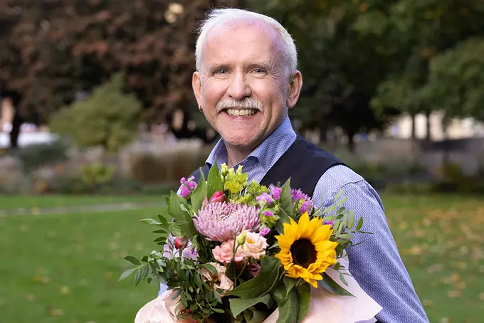 Bild på Jerry Johansson med blombukett i famnen, vinnare av Årets hbtqi-pris