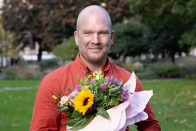 Bild på Mathias Wadstedt med blombukett, vinnare av Årets Arbetsmiljö 2024
