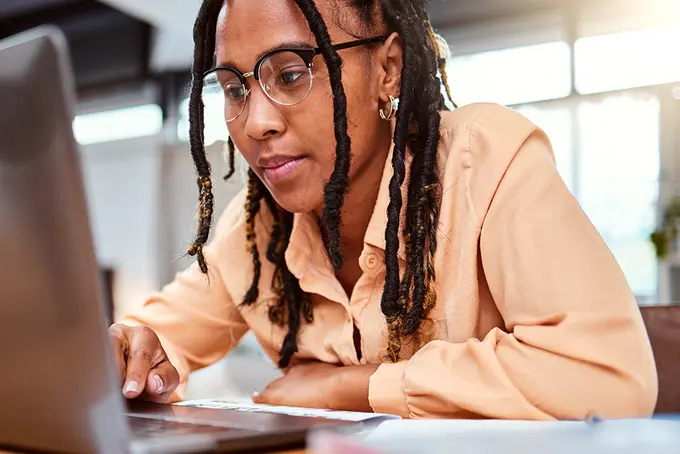 Person som fokuserat skriver på en laptop.