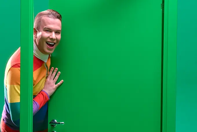 Farao Groth tittar ut bakom grön dörr