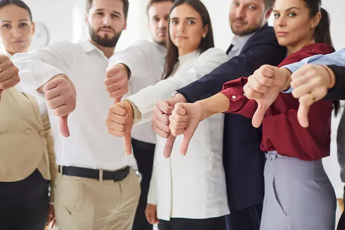 En grupp människor som gör tummen ner