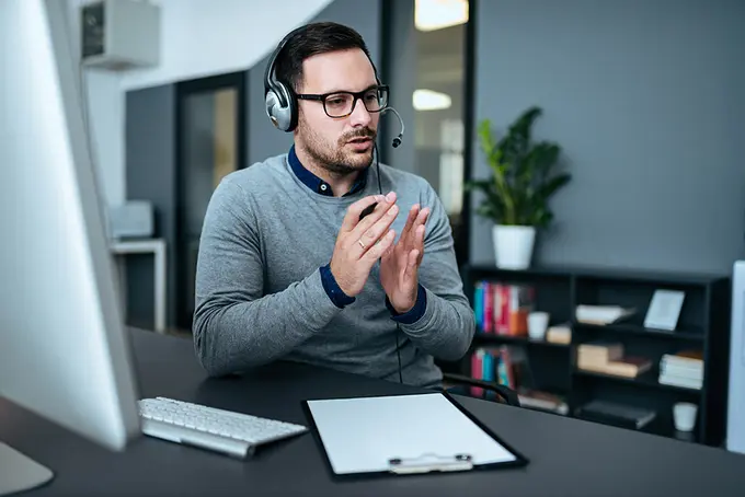 Man i kontorsmiljö som pratar i trådlöst headset