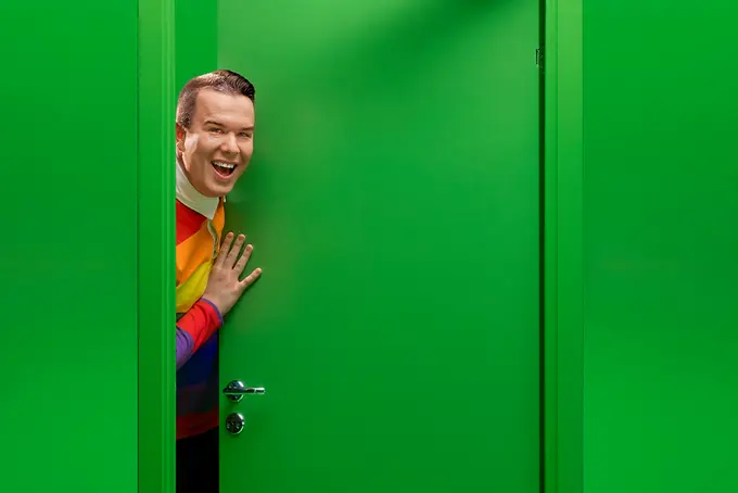 Farao Groth tittar ut bakom grön dörr