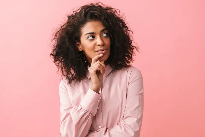 Ung person med finurlig min står och funderar på att bli medlem. 