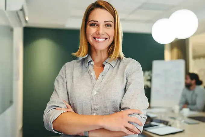 Glad kvinna i kontorsmiljö