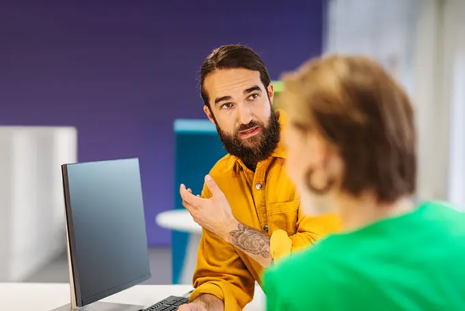 Man med skägg framför en datorskärm
