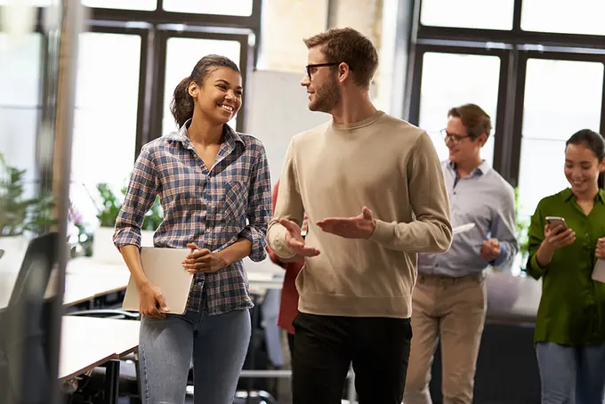 Manlig och kvinnlig kollega i vänligt samtal på jobbet