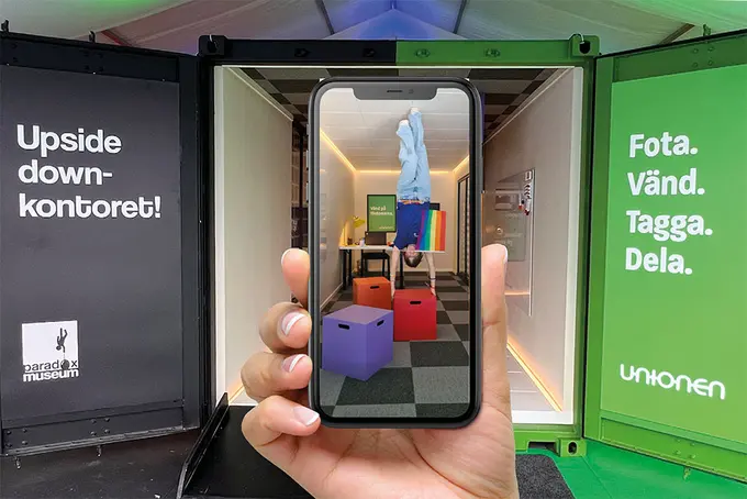 Svart och grön container med mobilkamera framför