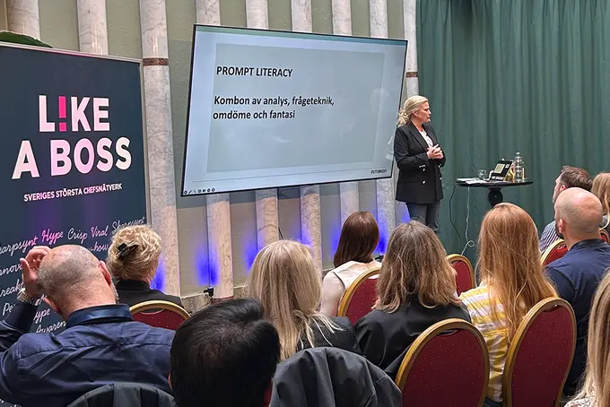 Kvinna talar på scen inför publik