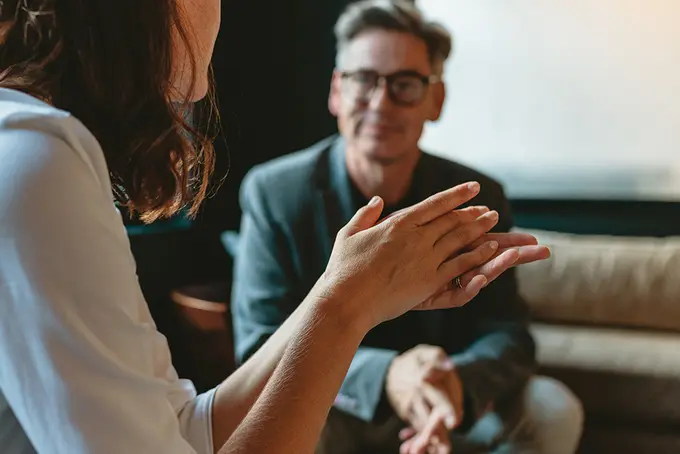 Två kollegor som samtalar (en kvinna och en man). 