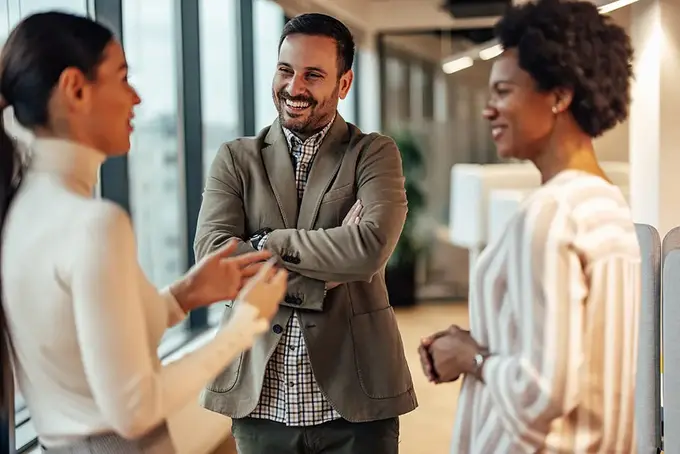 Tre kollegor samtalar i kontorsmiljö