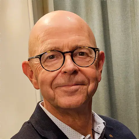 Man med glasögon tittar in i kameran